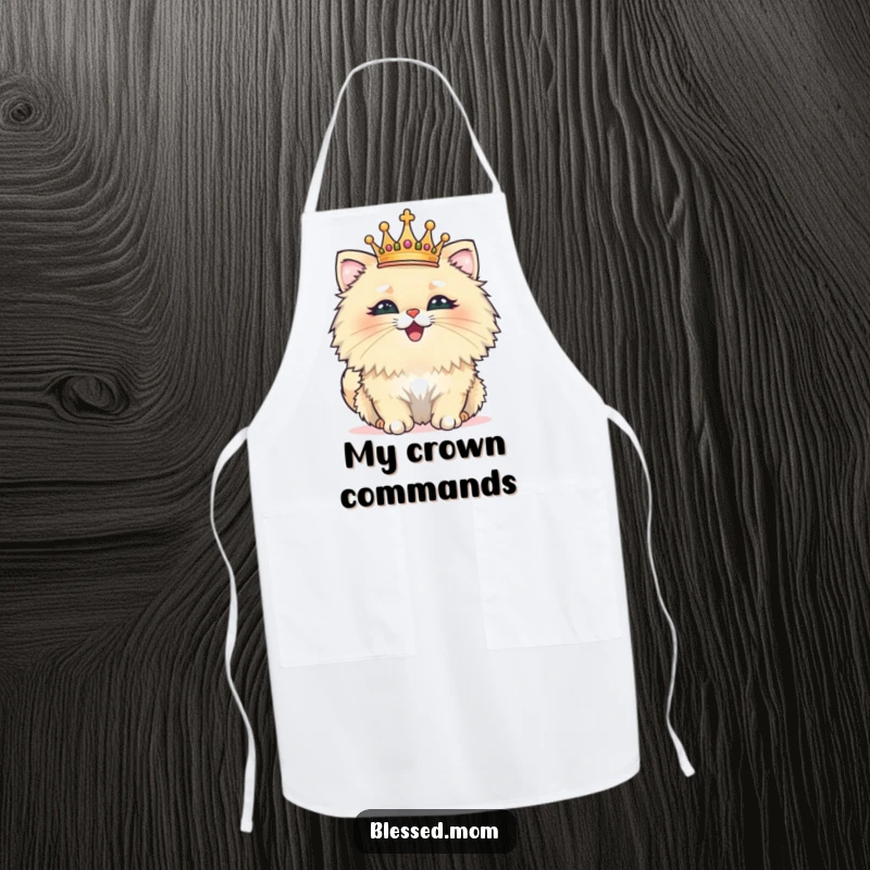 Funny apron showcasing a fluffy cat wearing a tiny crown, beaming with pride, ideal for cooking or baking with humor.