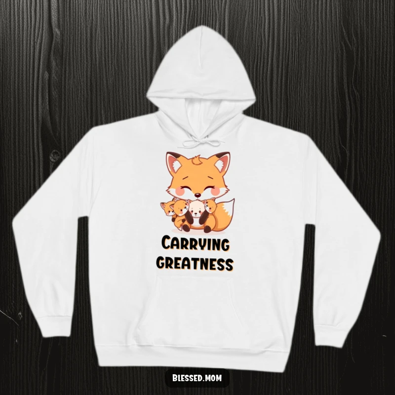 Funny Mama Fox hoodie shows a cute fox carrying her kits playfully in her mouth, symbolizing warmth and maternal joy.